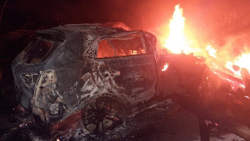Carro é arrastado por caminhão após colisão e motorista pula de veículo, que pega fogo